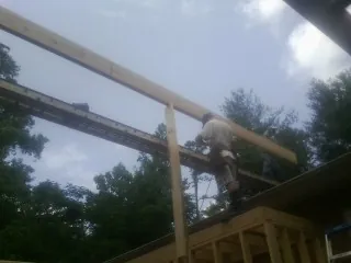 Carpenter setting a ridge beam over a new addition frame — Ice Dam Removal by Roofing Brothers in Boulder Creek